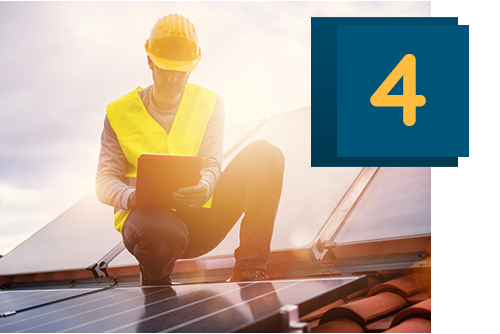 Männer in Warnwesten stehen auf einer Baustelle und sehen sich Pläne an.